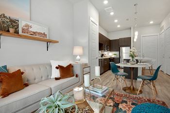 A modern living room with a grey sofa and a coffee table with a plant on it.
