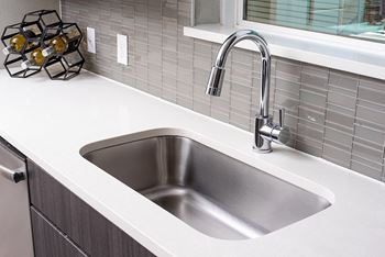 A modern kitchen sink with a chrome faucet.