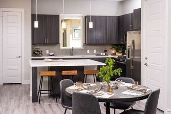 A modern kitchen with a dining table set for four.