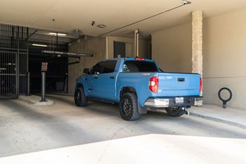 A blue pickup truck is parked in a garage.