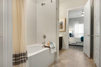 A bathroom with a white tub and a towel that says Legoraj.