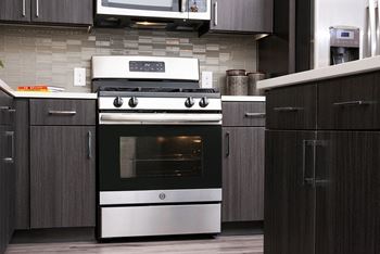 A modern kitchen with a stove and cabinets.