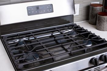 A modern gas stove with a digital control panel.