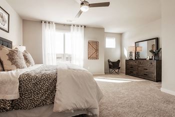A bedroom with a large bed and a ceiling fan.