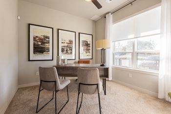 A dining room with a table and chairs.