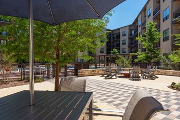 A patio with a table and chairs under an umbrella.