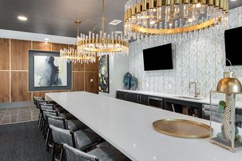 A long white table with a gold tray on it.