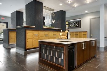 A kitchen with a black and white tiled backsplash and wooden cabinets.