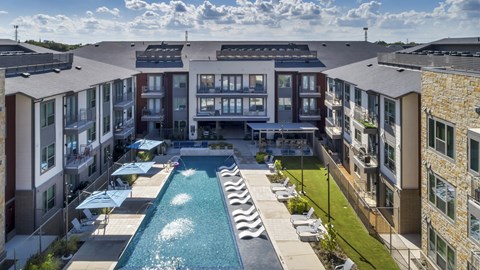 A swimming pool is surrounded by apartment buildings.