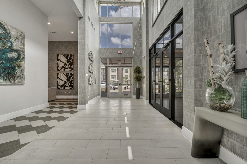 A hallway with a checkered floor and a large painting on the wall.