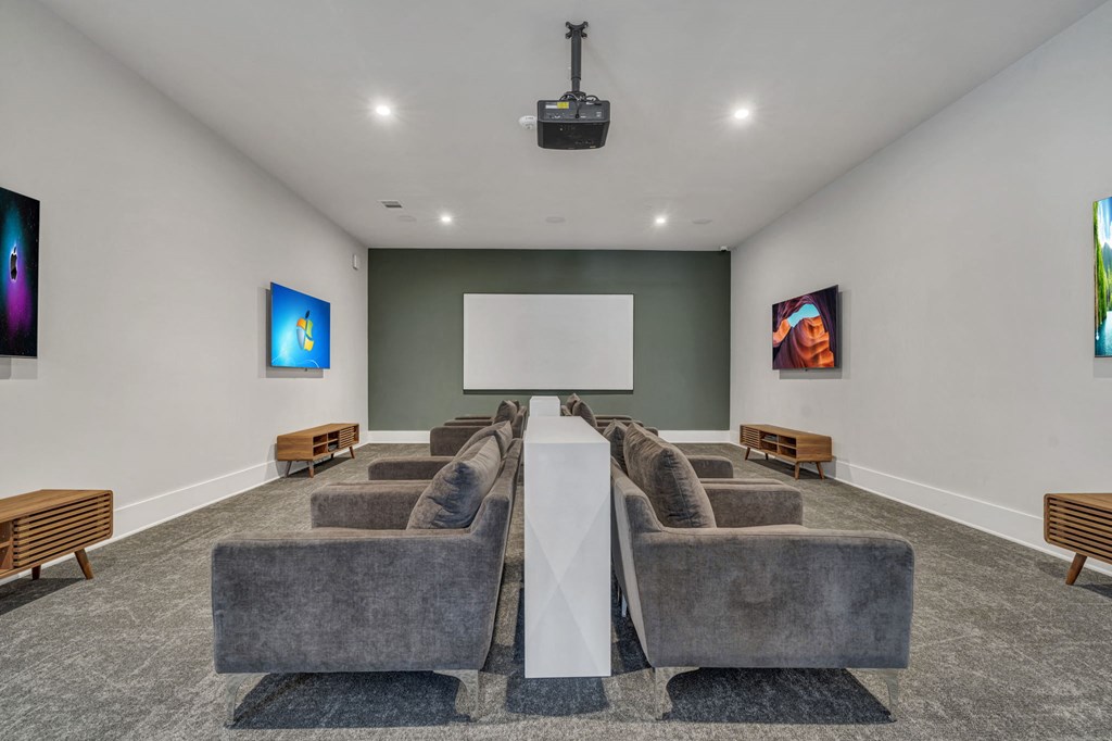 A room with grey chairs and a white screen in the middle.