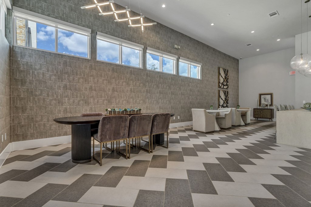 A room with a checkered floor and a long table with chairs.