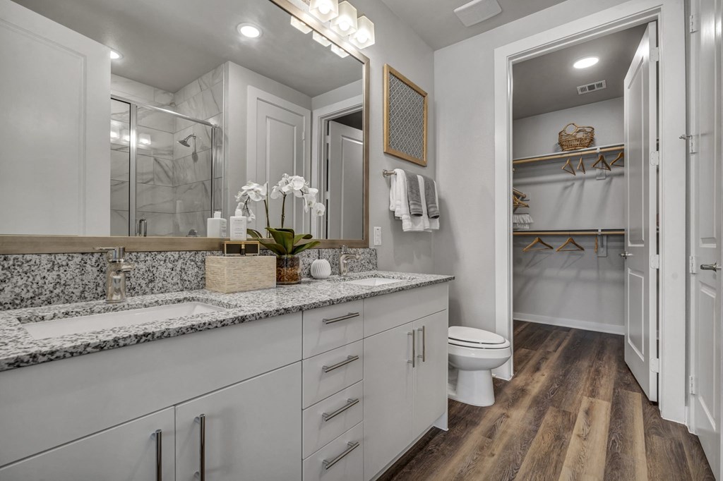 A bathroom with a toilet, sink, and mirror.