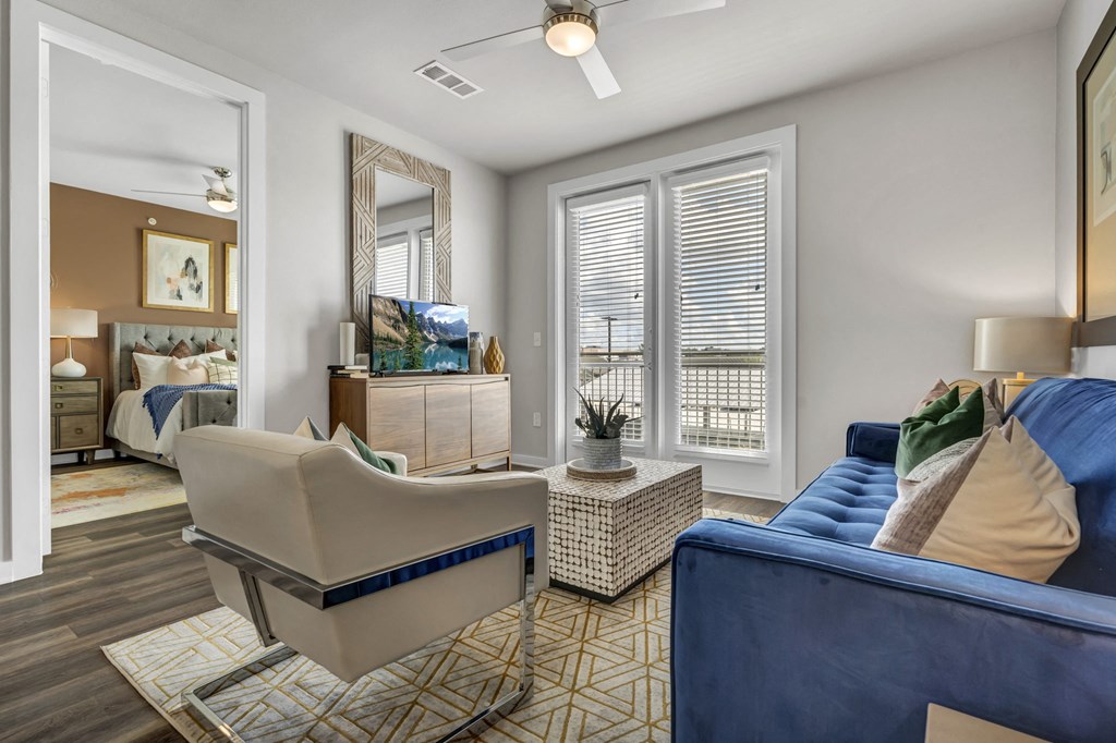 A living room with a blue couch and a beige chair.