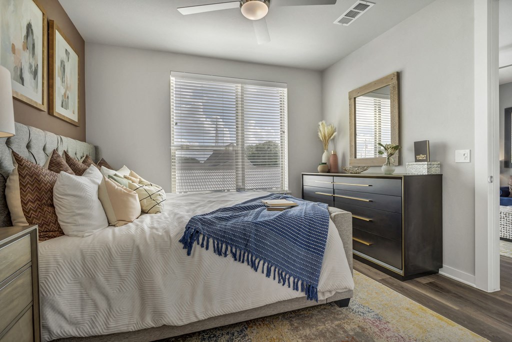 A bedroom with a bed, dresser, and mirror.