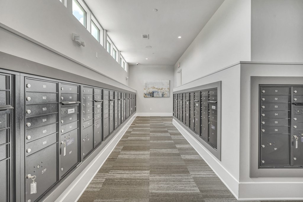 A long hallway with a carpeted floor and a series of lockers on both sides.