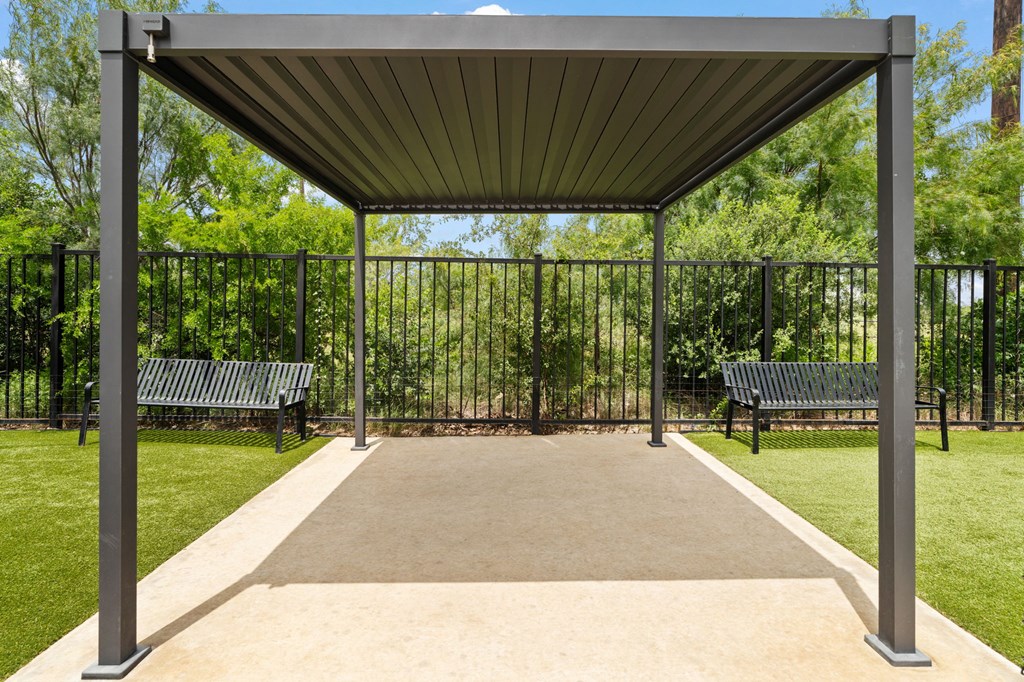 A park with a bench and a canopy.