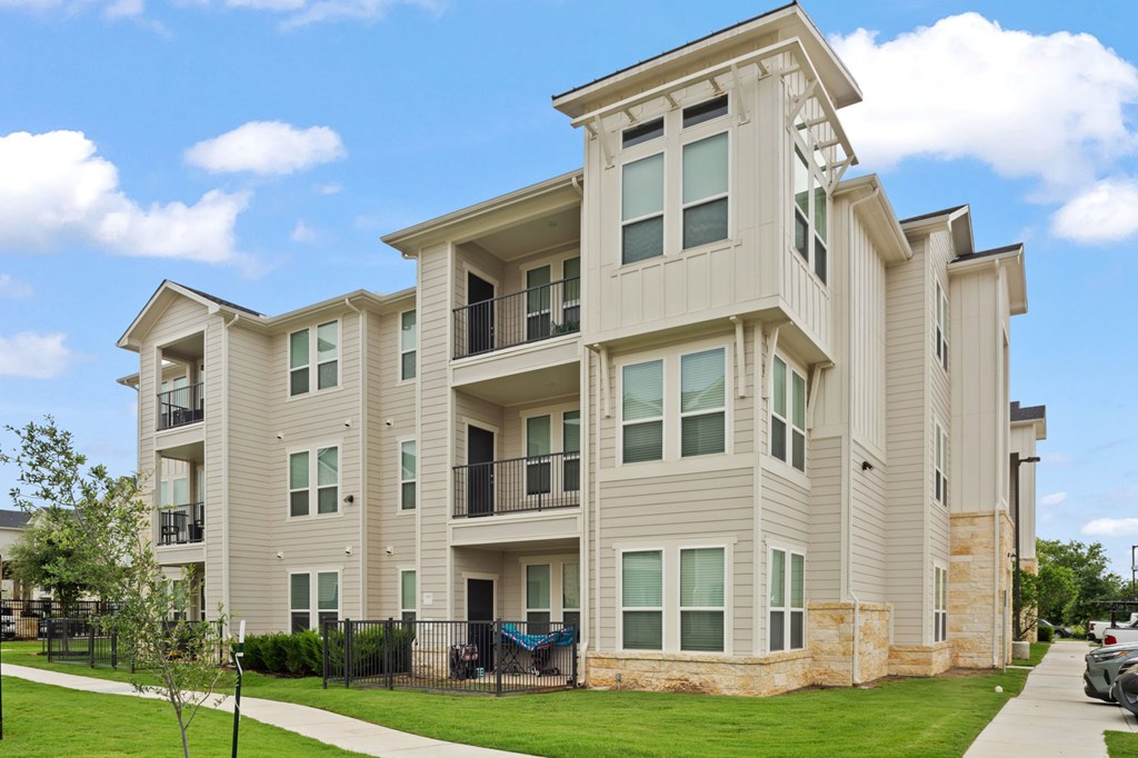 A large, modern apartment building with a balcony on the second floor.