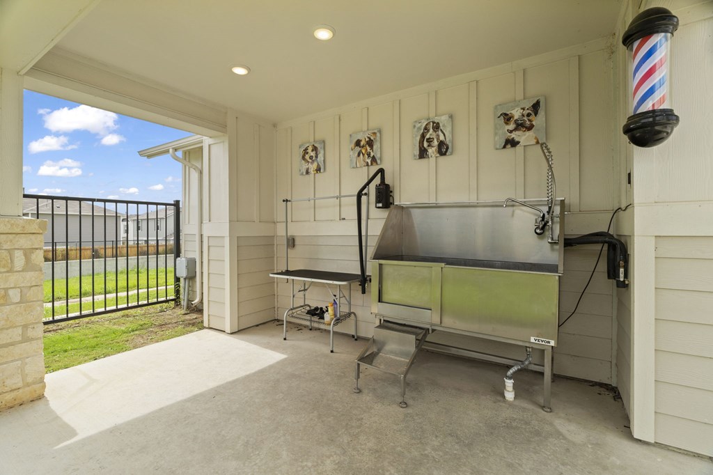 A barber shop with a table and chairs and a sink.