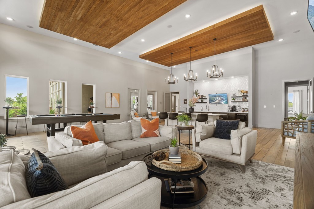 A modern living room with a wooden ceiling and a large sectional sofa.