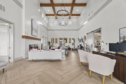 A modern living room with a white sofa and a wooden floor.