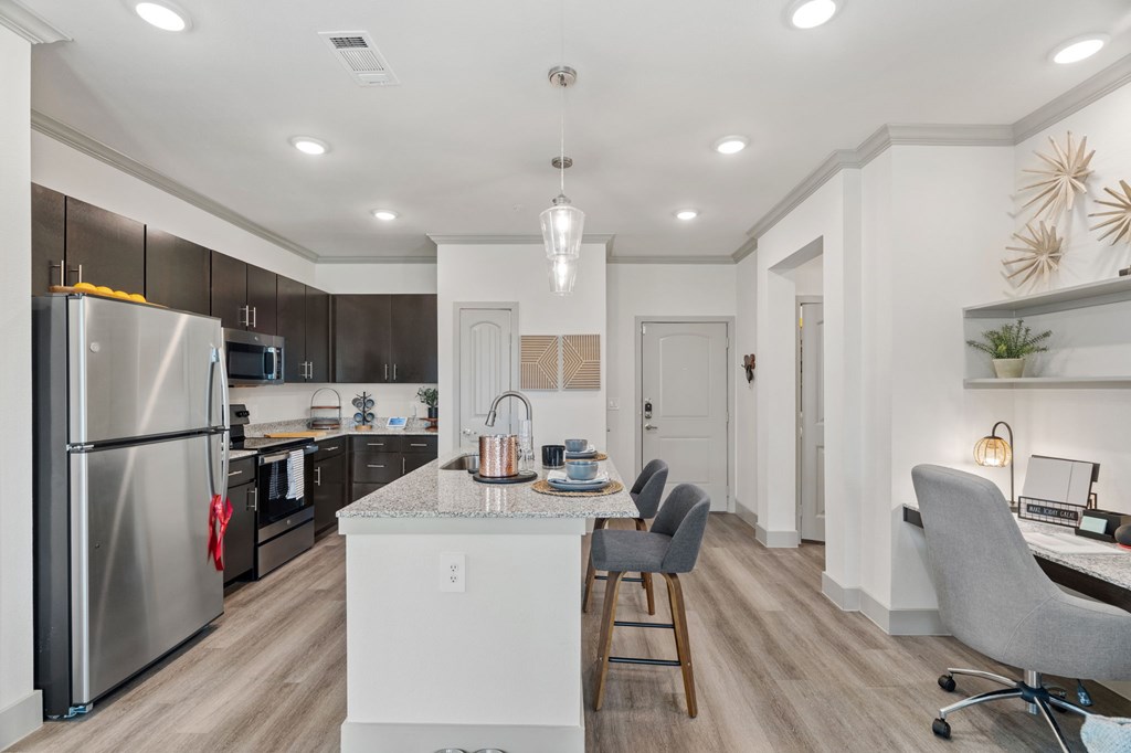 A modern kitchen with a refrigerator, sink, and dining table.