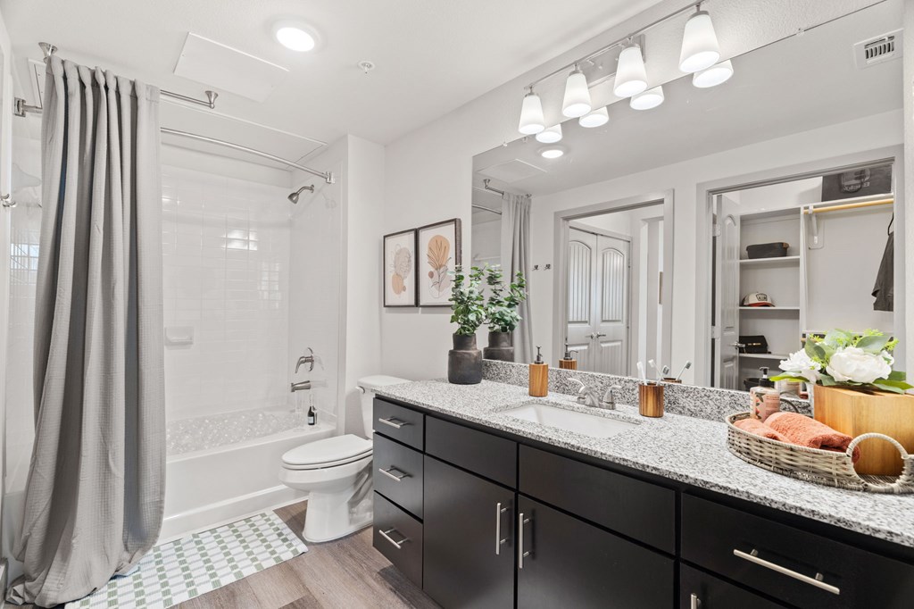 A bathroom with a white toilet, a sink, and a mirror.