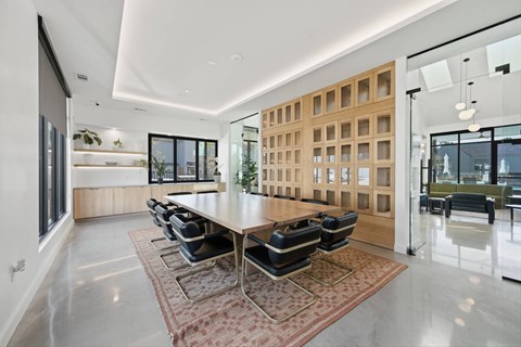 A modern dining room with a long table and chairs.