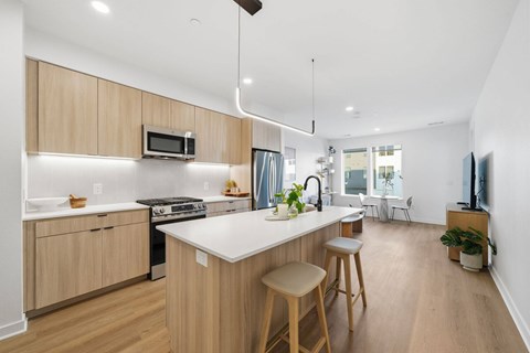 A modern kitchen with wooden cabinets and a white island.