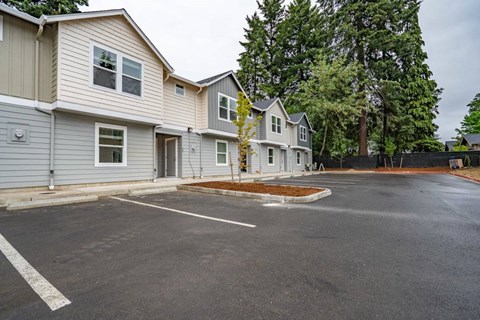 A parking lot in front of a row of houses.