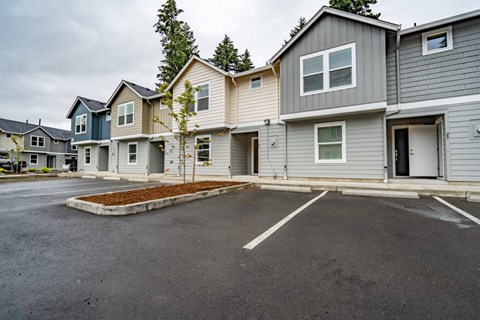 A parking lot in front of a row of houses.
