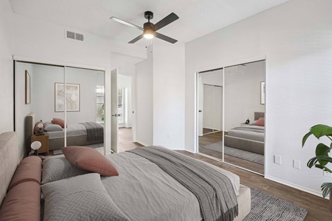 A bedroom with a large bed and a ceiling fan.
