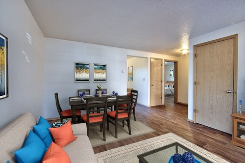 the living room and dining room of an apartment with a table and chairs