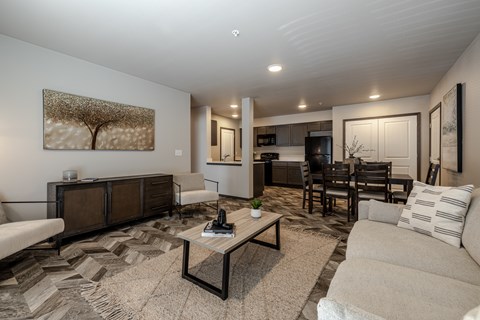 A living room with a white couch, a coffee table, and a painting on the wall.