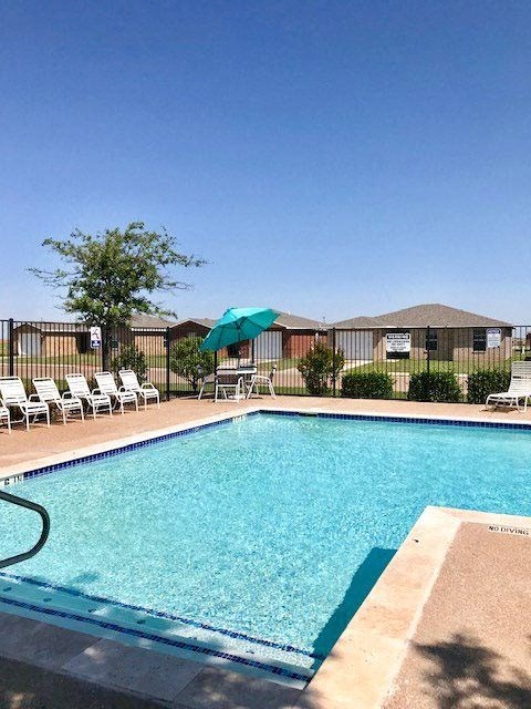 a swimming pool with chairs and an umbrella