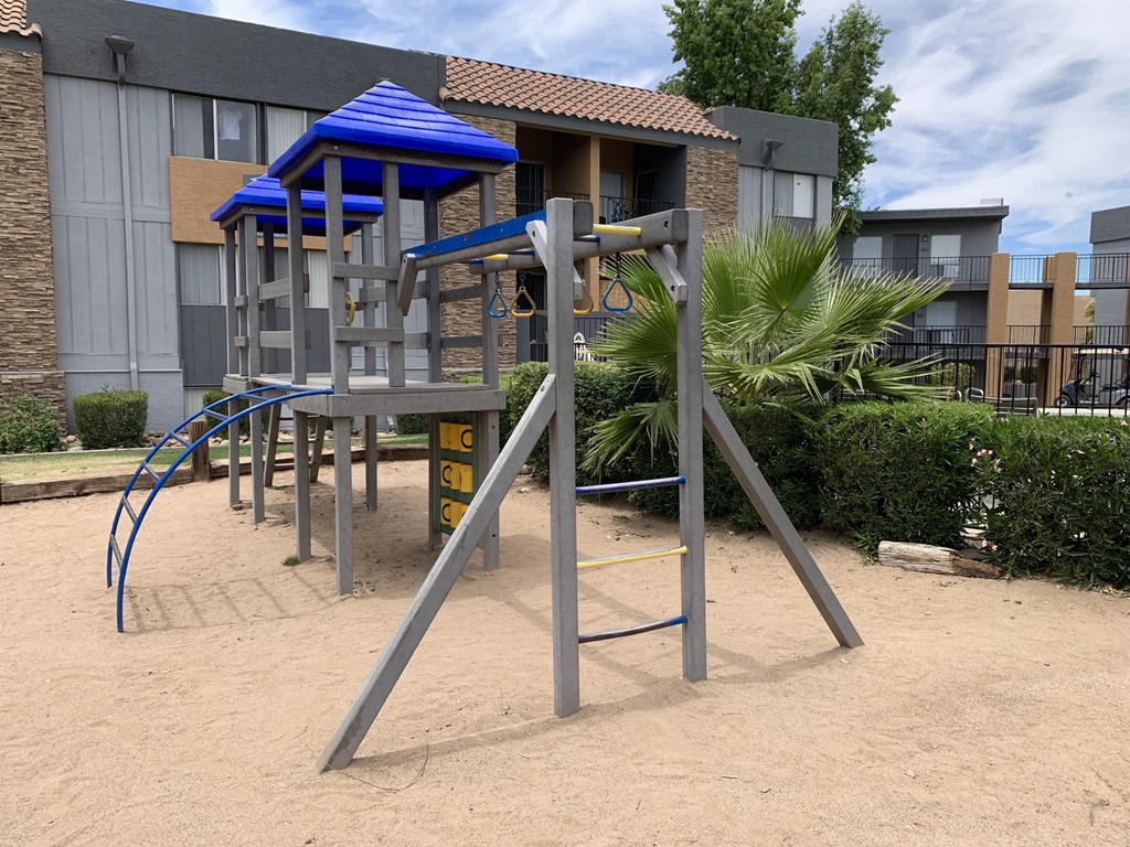 a playground with a swing set in front of a building
