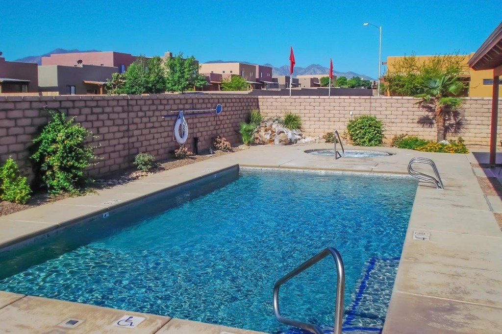 A swimming pool surrounded by a wall and some plants.
