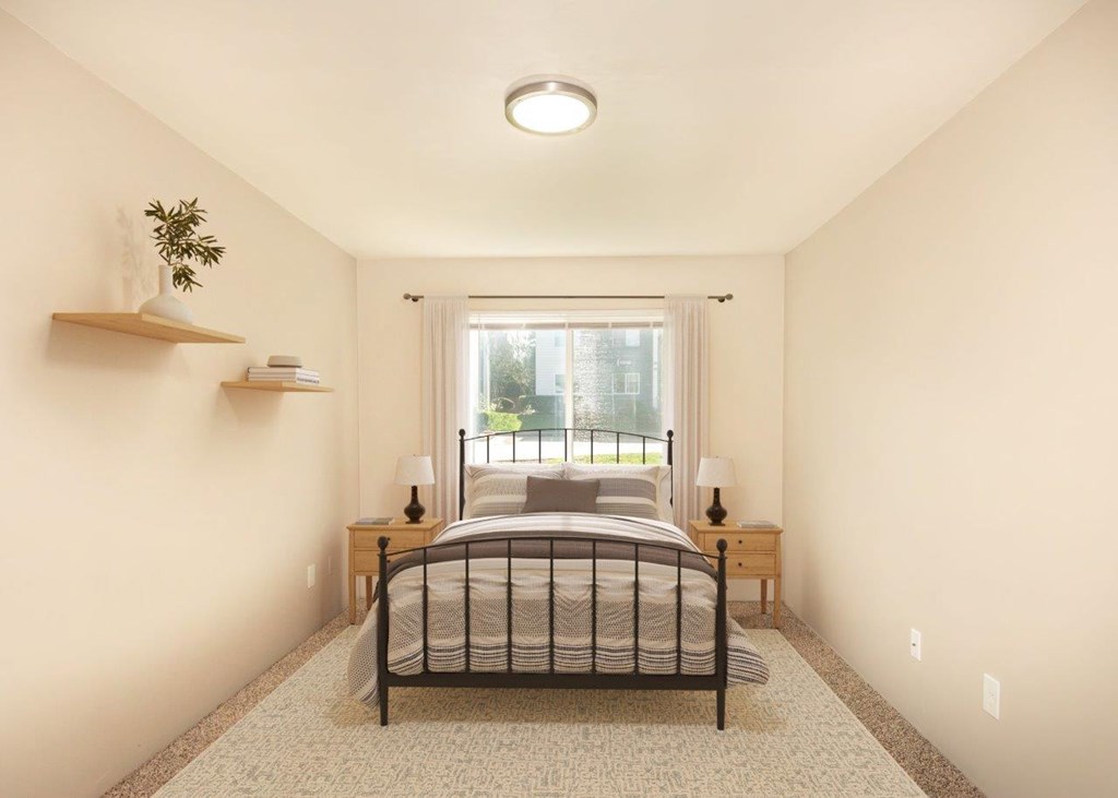 A bedroom with a bed, nightstands, and a window.