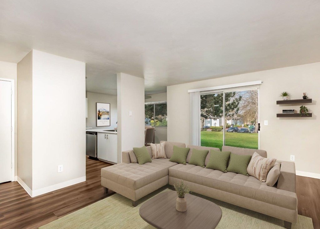 A living room with a couch, a coffee table, and a window.