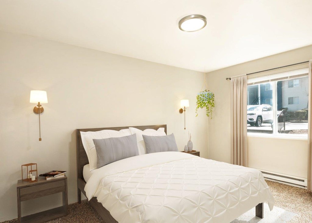 A bedroom with a large bed and a window overlooking a street.