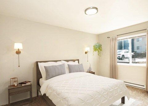 A bedroom with a large bed and a window overlooking a street.