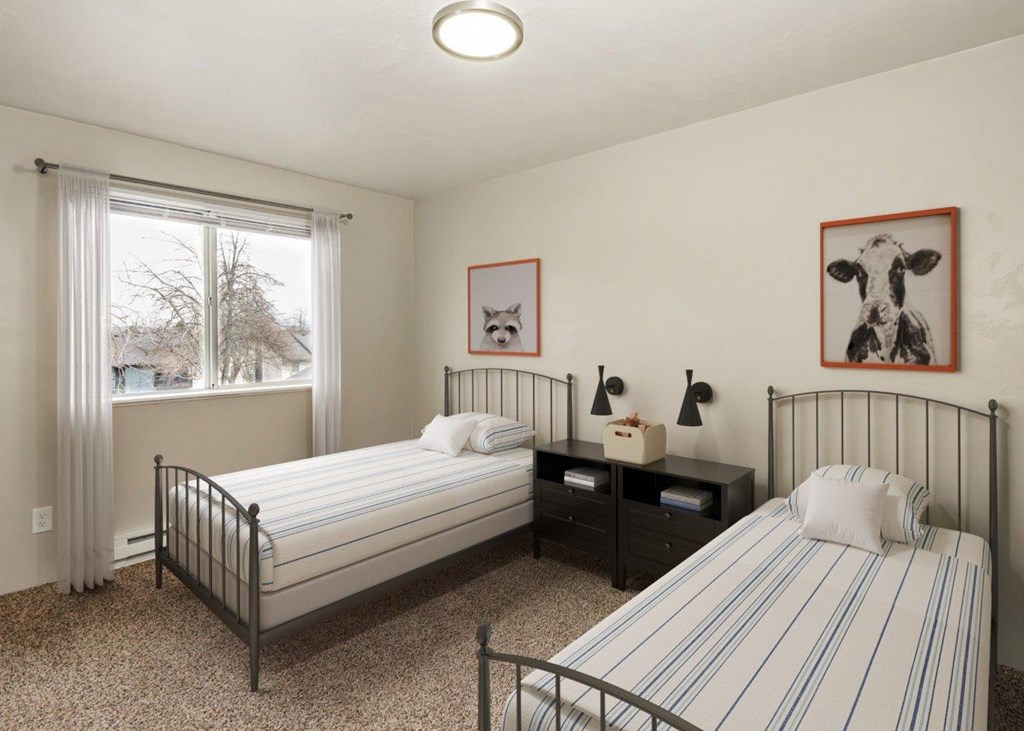 A bedroom with two beds, one with a striped bedspread.