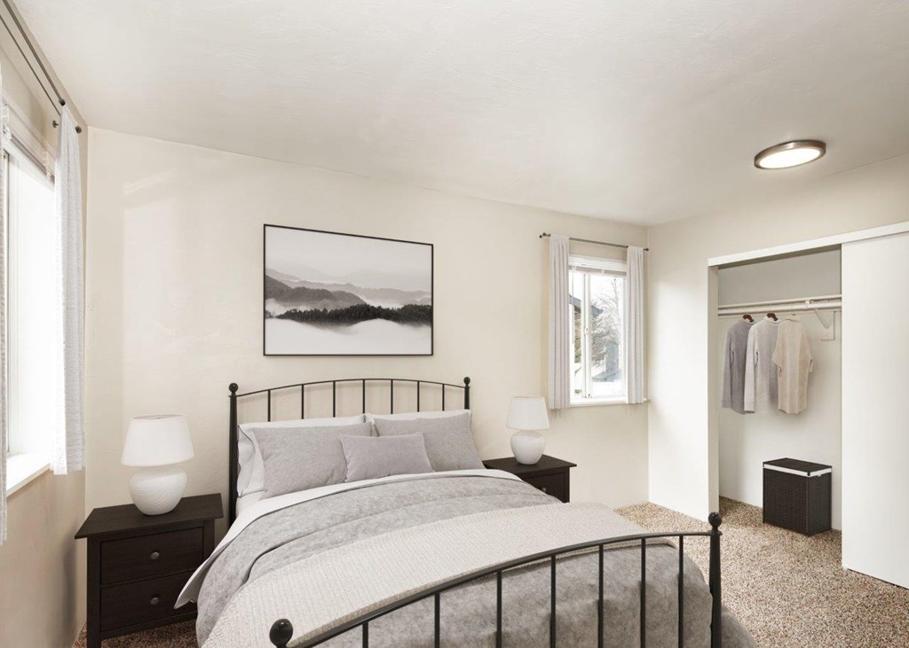 A bedroom with a large bed and a picture on the wall.