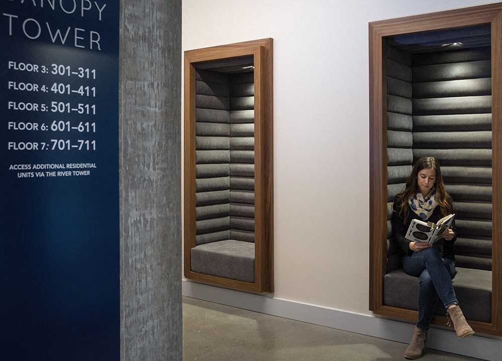 a woman sitting in a chair reading a book in a room