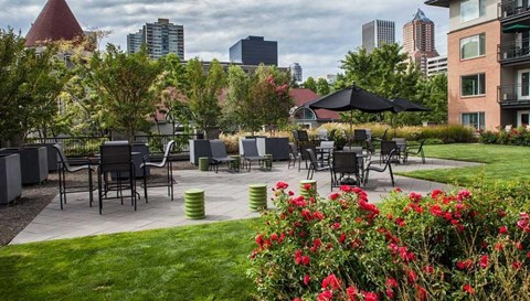 an outdoor patio with tables and chairs and a city skyline in the background