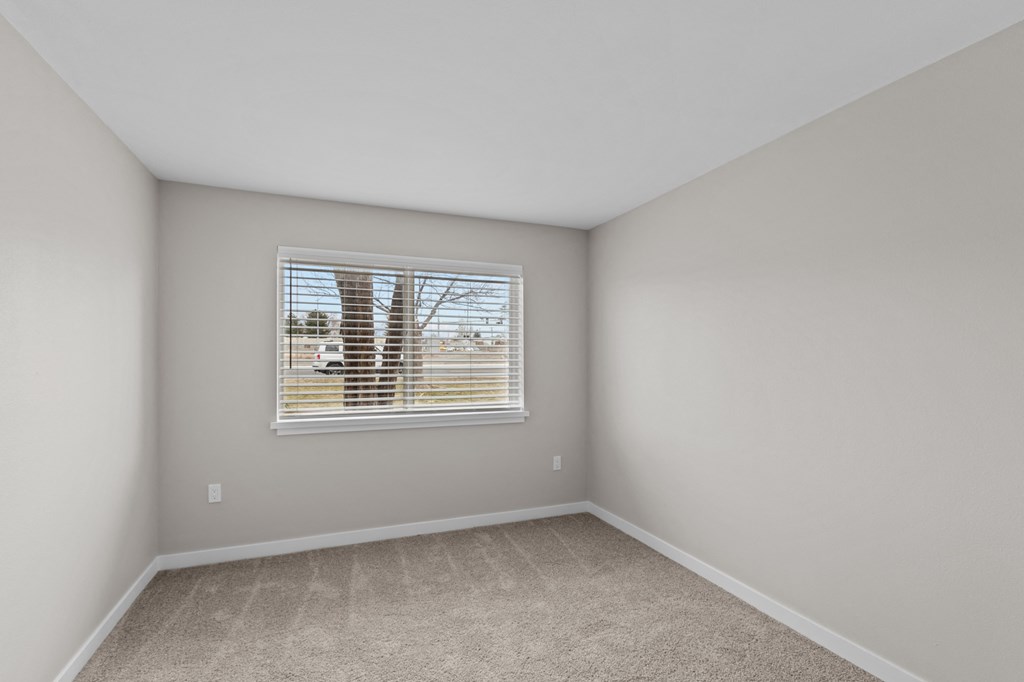 a bedroom with gray walls and a window