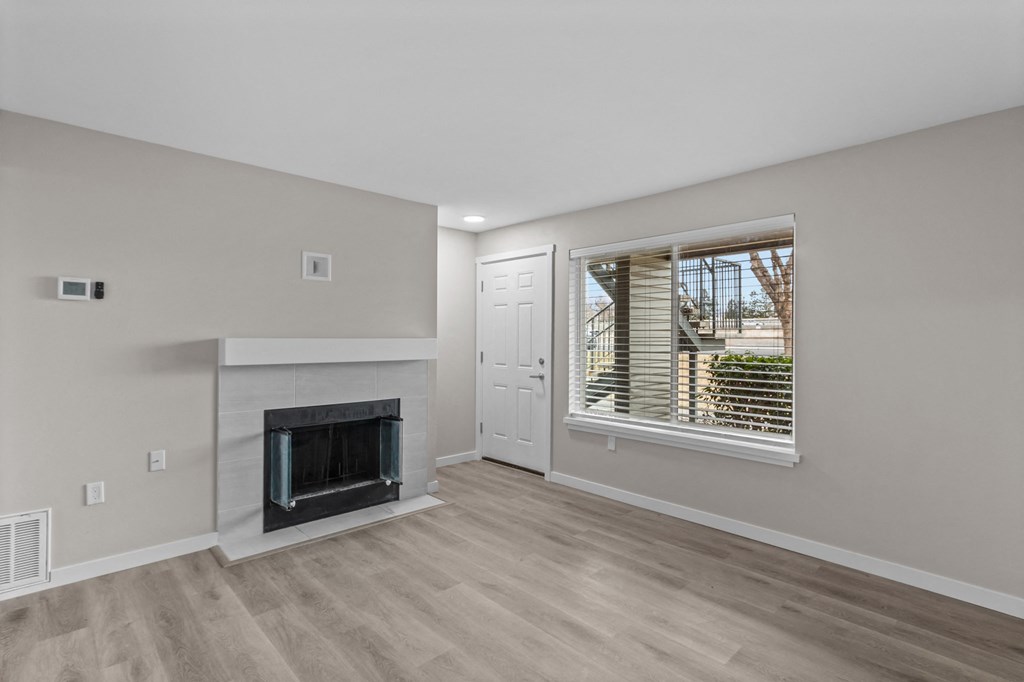 a living room with a fireplace and a large window