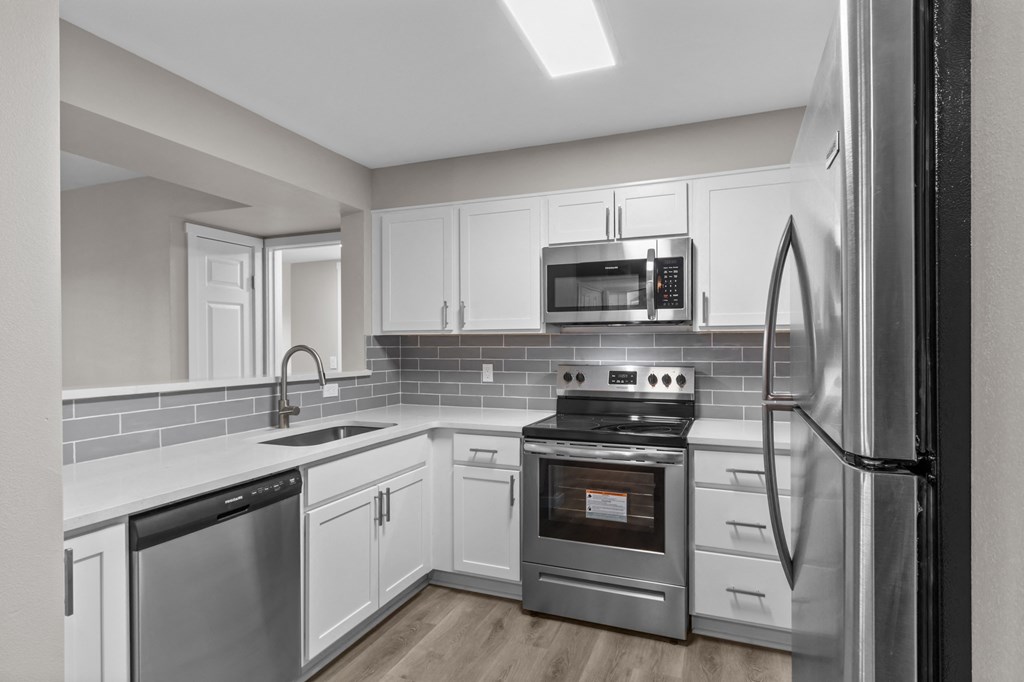 a kitchen with white cabinets and stainless steel appliances