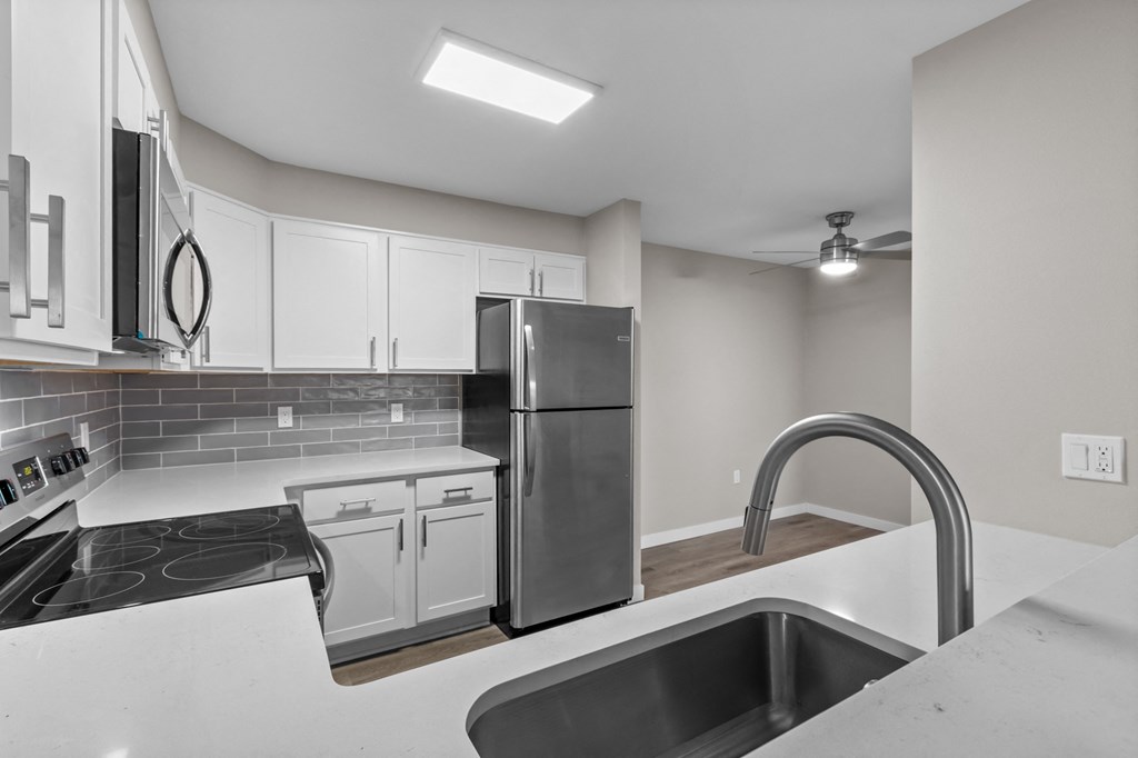 a kitchen with white cabinets and stainless steel appliances