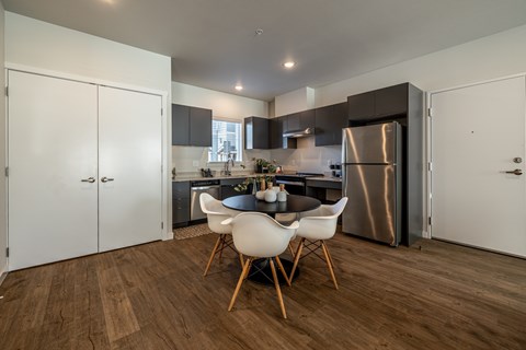 A modern kitchen with a dining table and chairs.